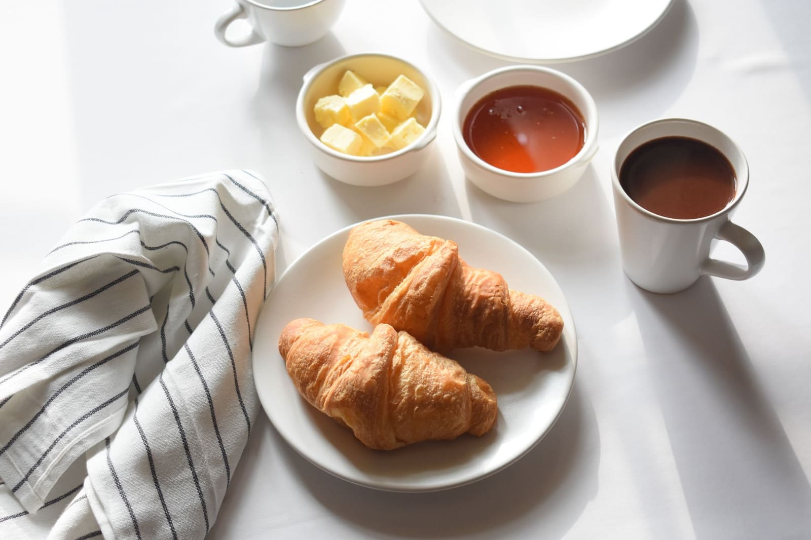 Croissants, café, beurre et confiture pour un petit-déjeuner